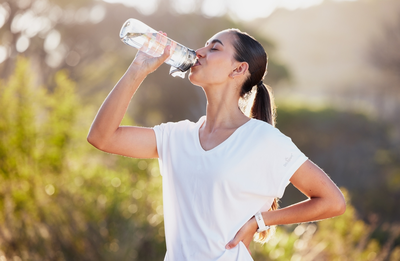 woman drinking water outside