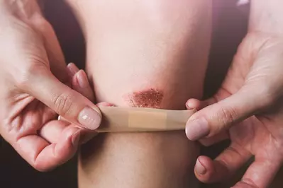 person putting bandage on cut